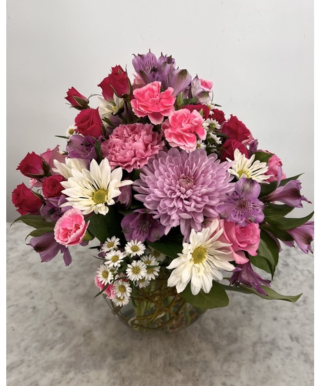 Bubble bowl filled with pink, purple and white daisies, carnations and alstroemeria