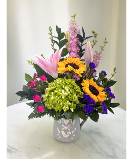 Fresh flowers, including Pink Larkspur, Pink Lilies, Sunflowers, and Hydrangea.